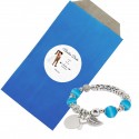 Pulsera en sobre kraft azul con adhesivo personalizado con nombre de invitada y novios para bodas